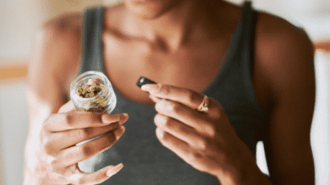 woman holding cannabis marijuana jar